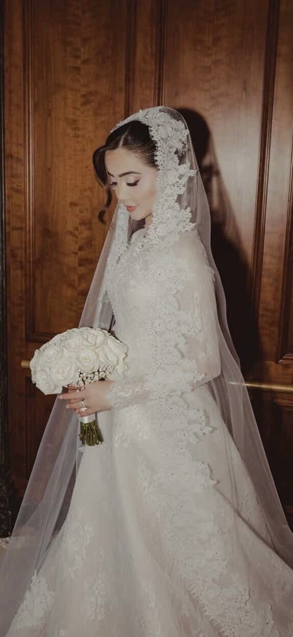 Bride in full lace veil and gown with timeless bridal makeup