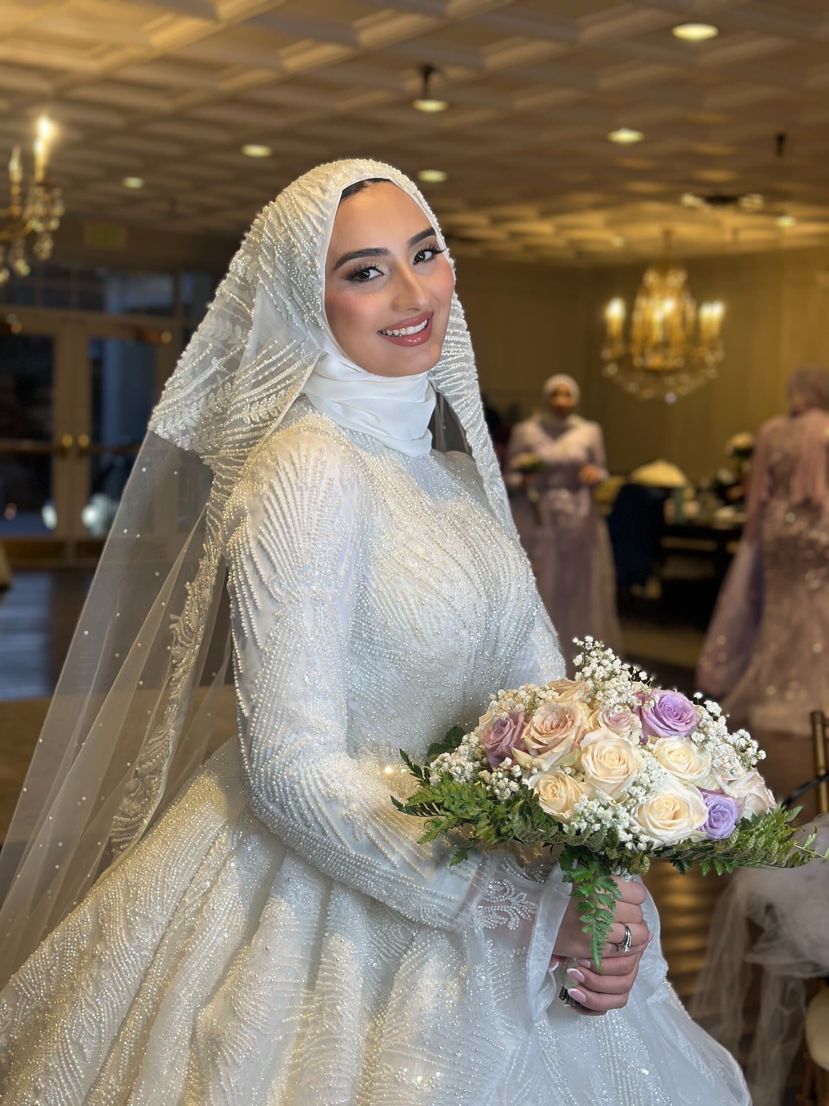 Hijab bride with bouquet and elegant bridal makeup