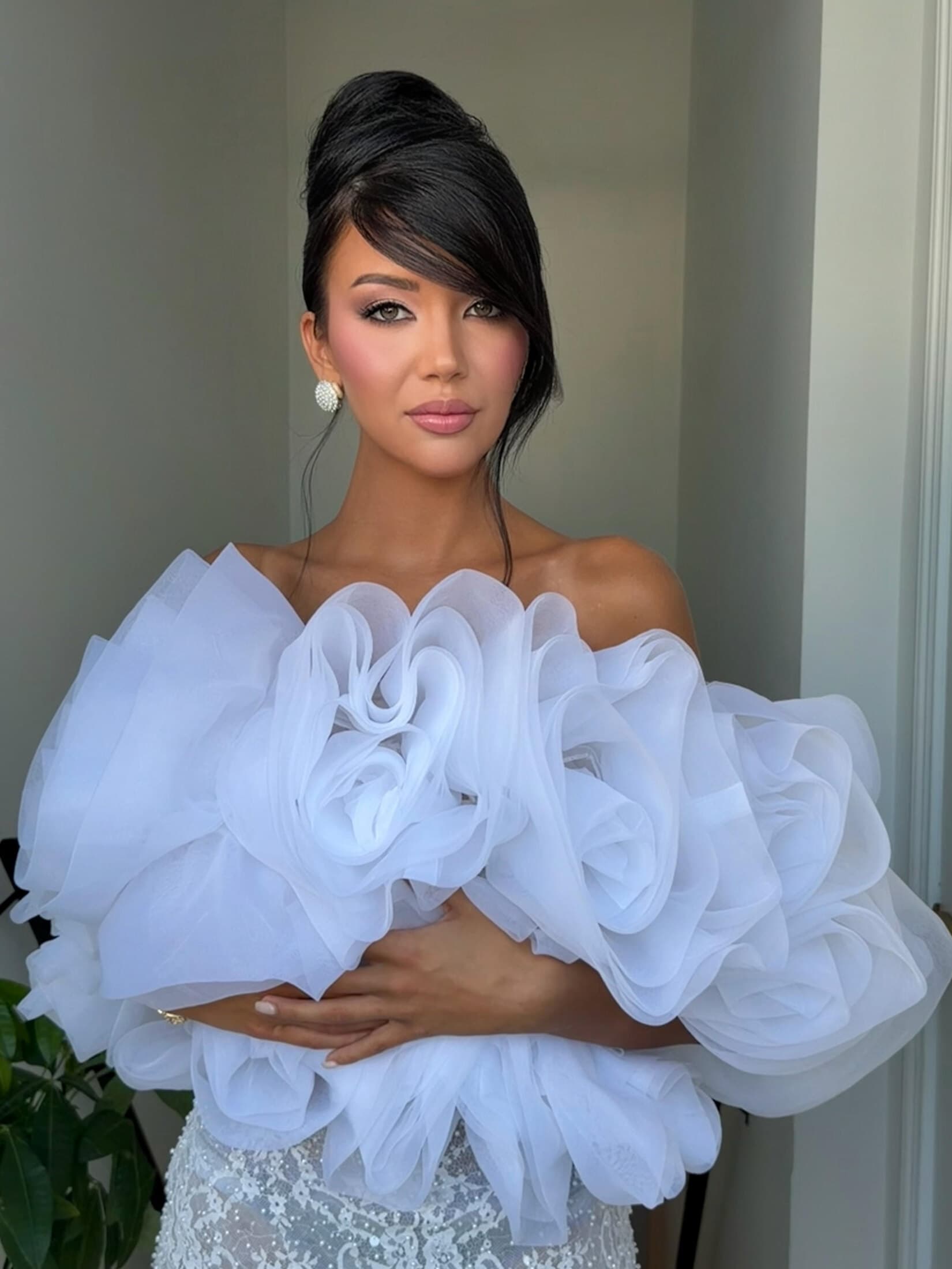 Bride in dramatic ruffled gown with sculpted updo and glam makeup by Malaz